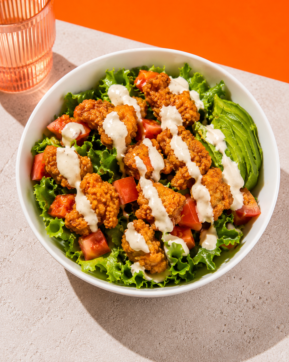 A buffalo crispy tofu salad with avocado and ranch dressing