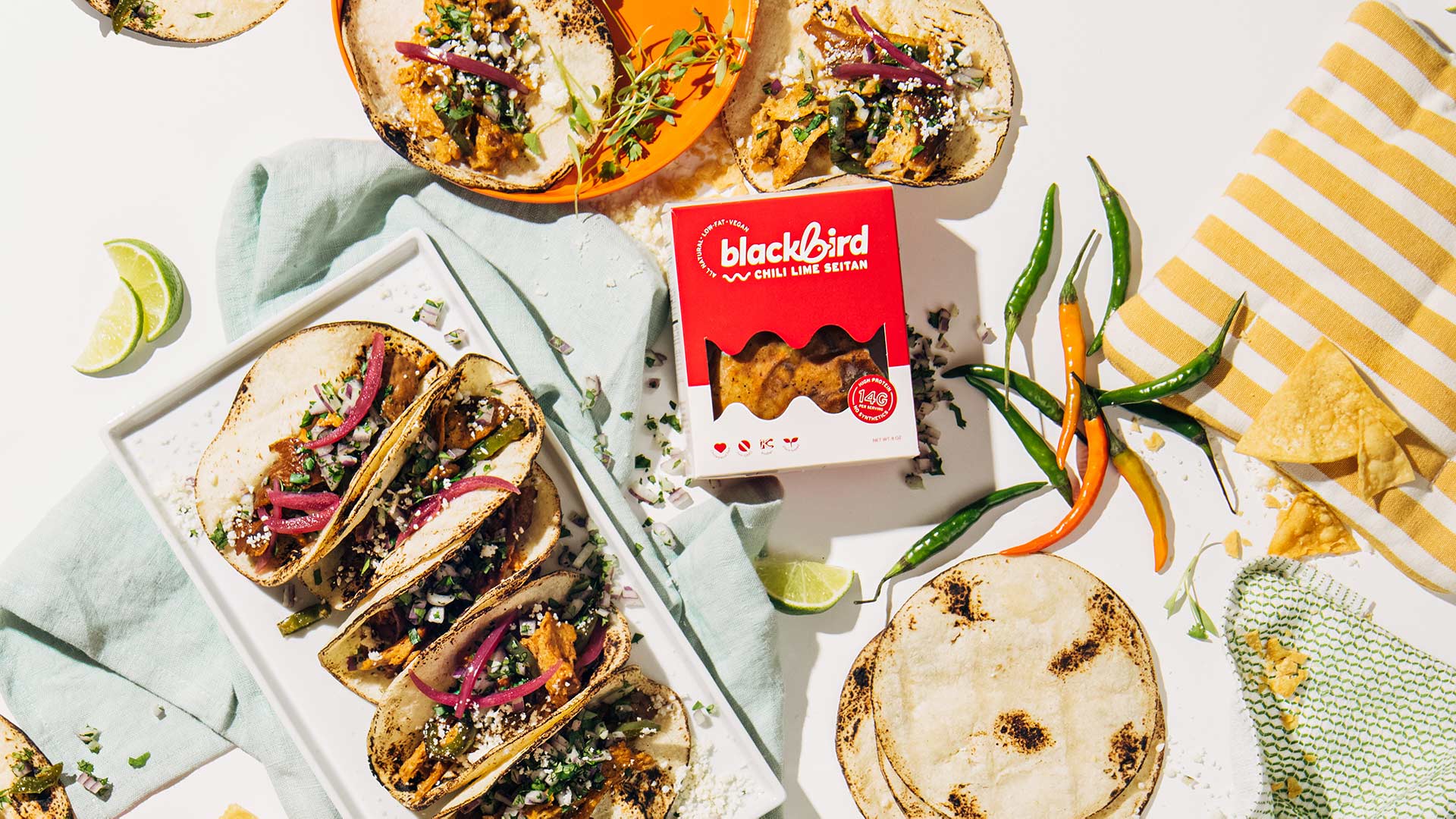 Chili lime seitan tacos on a platter beside a Blackbird Chili Lime Seitan box